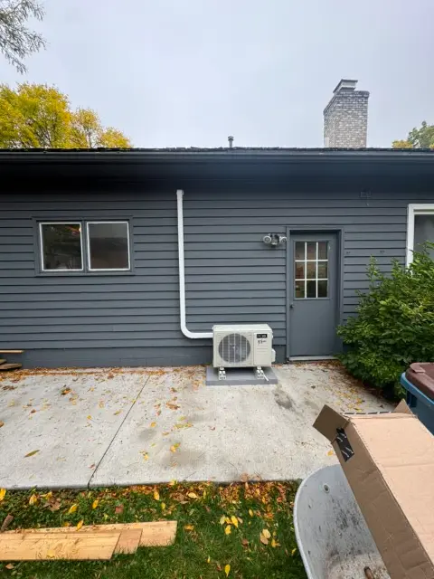 Mini-split air conditioning unit mounted on exterior wall in Maple Grove