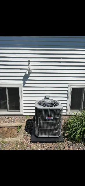 Mini-split air conditioning unit mounted on exterior wall in Maple Grove